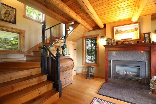 stairway featuring wood ceiling, a wealth of natural light, lofted ceiling with beams, and hardwood / wood-style flooring