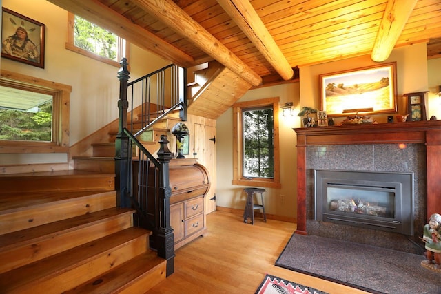 interior space with wooden ceiling, wood finished floors, beam ceiling, and a fireplace