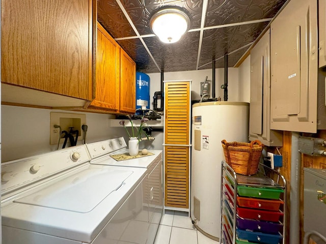 clothes washing area with electric panel, light tile patterned floors, cabinets, independent washer and dryer, and electric water heater