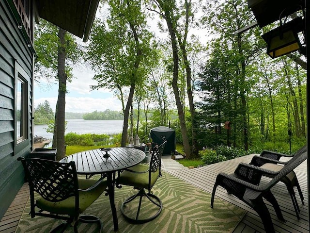 wooden deck featuring outdoor dining space and a water view