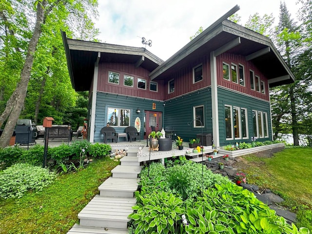 rear view of house featuring board and batten siding and a patio