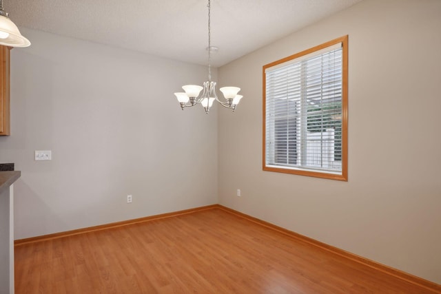 empty room featuring hardwood / wood-style floors and an inviting chandelier