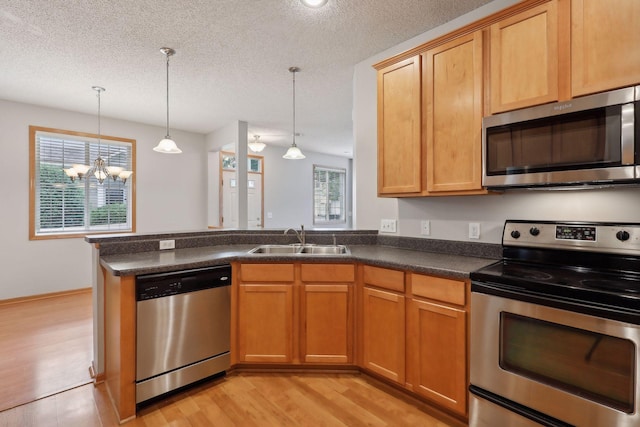 kitchen with a chandelier, sink, stainless steel appliances, and plenty of natural light