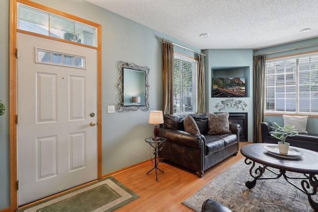 entrance foyer with hardwood / wood-style floors and a textured ceiling