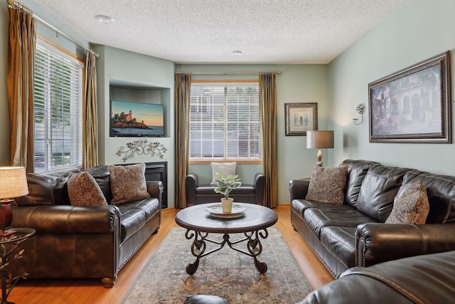 living room with a textured ceiling and light wood-type flooring