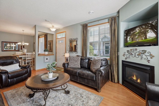 living room featuring a textured ceiling, hardwood / wood-style flooring, and a notable chandelier