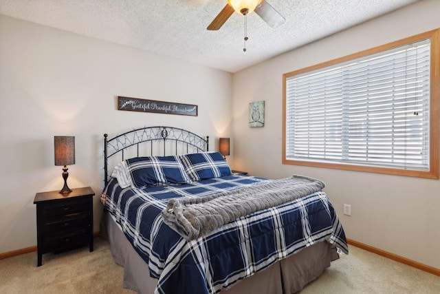 carpeted bedroom with ceiling fan and a textured ceiling