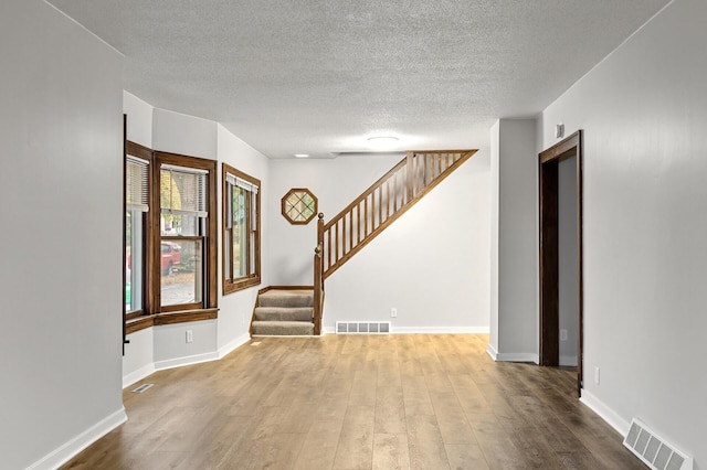 interior space with hardwood / wood-style flooring and a textured ceiling