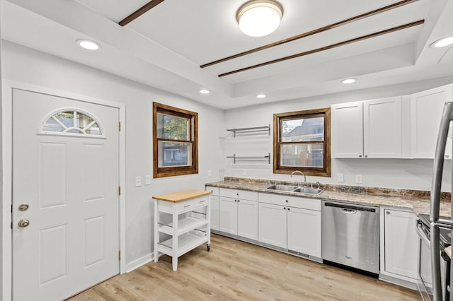 kitchen with sink, stainless steel appliances, white cabinets, a raised ceiling, and light wood-type flooring