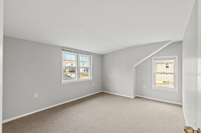 spare room featuring vaulted ceiling and carpet flooring