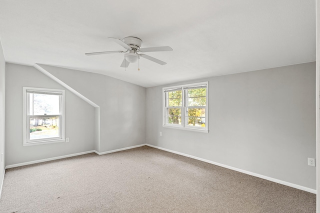 spare room featuring ceiling fan, vaulted ceiling, and carpet