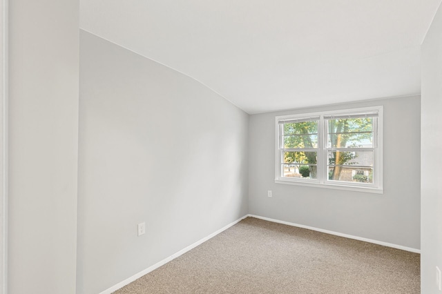 unfurnished room with carpet flooring and vaulted ceiling