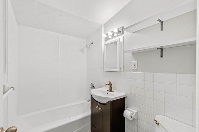 full bathroom featuring vanity, bathtub / shower combination, tile walls, and toilet