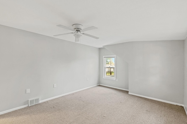 carpeted spare room featuring ceiling fan and vaulted ceiling