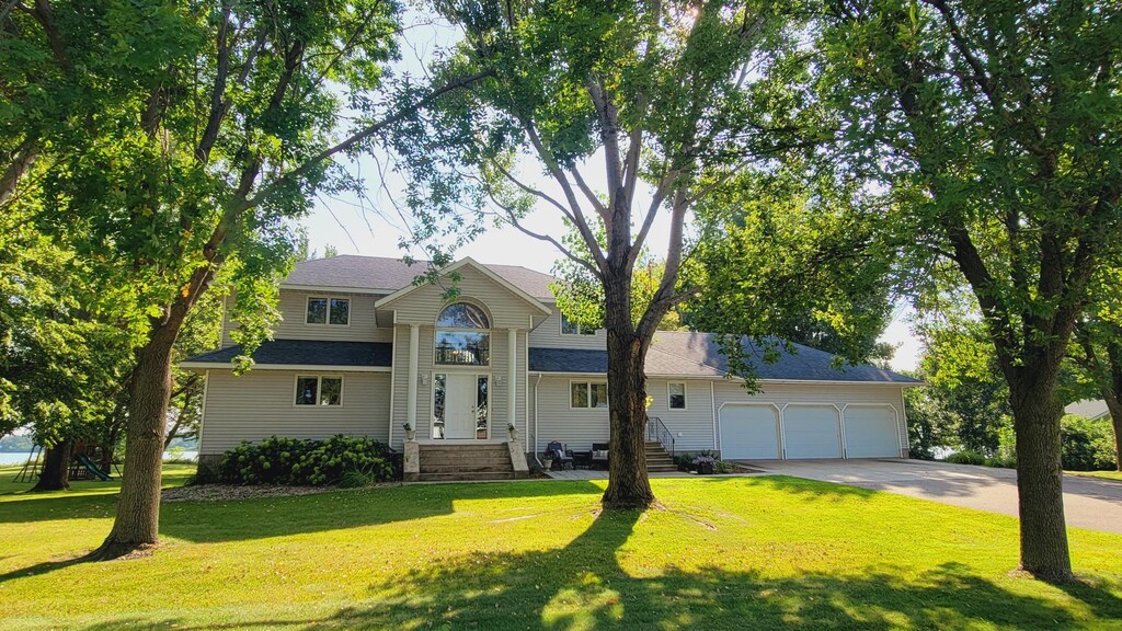 view of front of home featuring an attached garage, a front lawn, and concrete driveway