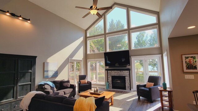 living room featuring a fireplace, ceiling fan, and high vaulted ceiling