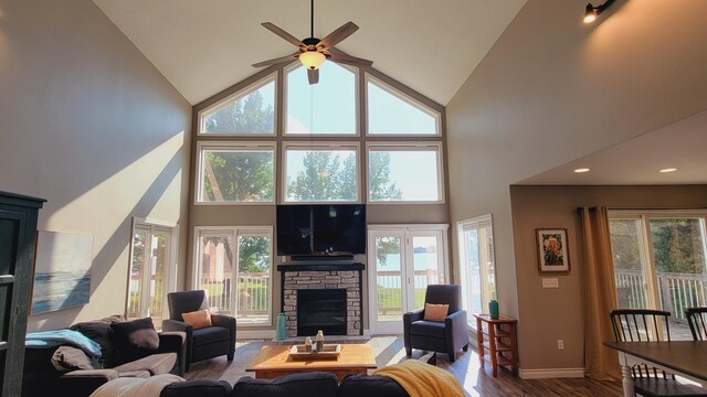 living room featuring a fireplace, ceiling fan, high vaulted ceiling, and hardwood / wood-style floors