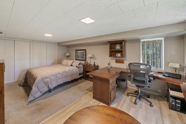 bedroom featuring two closets and light wood-type flooring