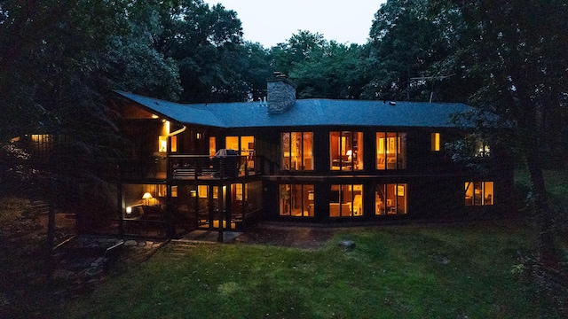 back house at dusk with a yard and a patio area