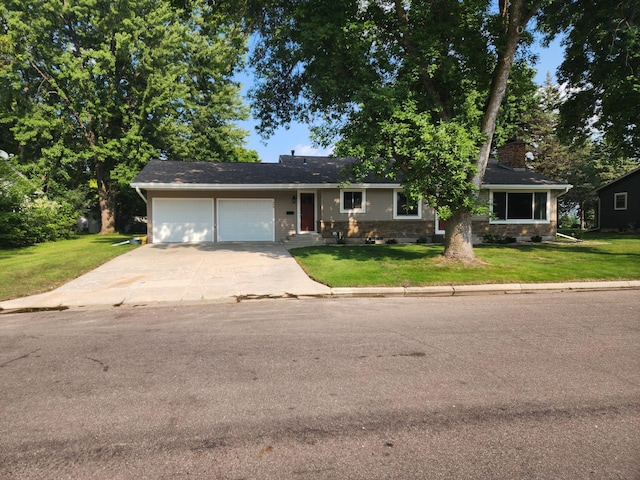 ranch-style house with brick siding, a chimney, an attached garage, a front yard, and driveway