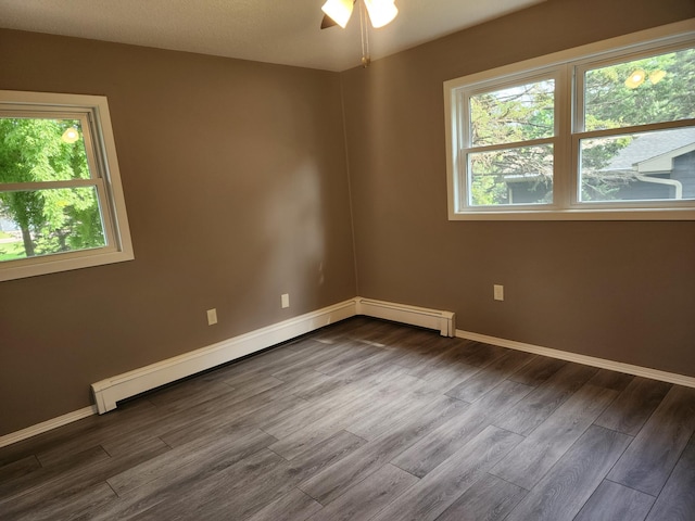 spare room with a healthy amount of sunlight, baseboards, and dark wood finished floors