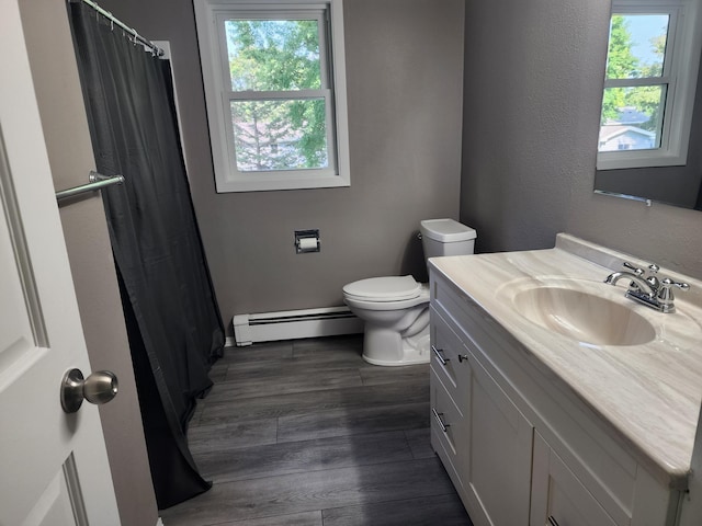 full bath featuring toilet, baseboard heating, wood finished floors, and a wealth of natural light