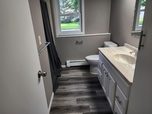 full bathroom featuring toilet, a baseboard heating unit, wood finished floors, vanity, and baseboards