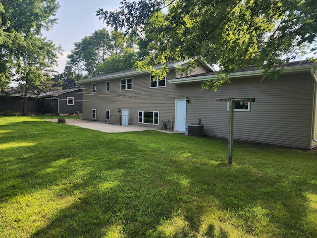 rear view of house with a patio area, a yard, and central AC unit