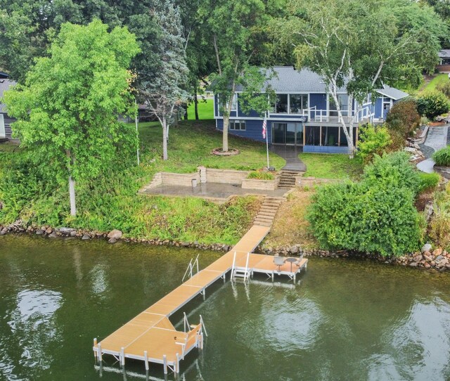 dock area featuring a lawn and a water view