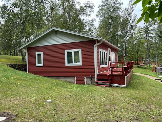 view of property exterior with a wooden deck and a yard