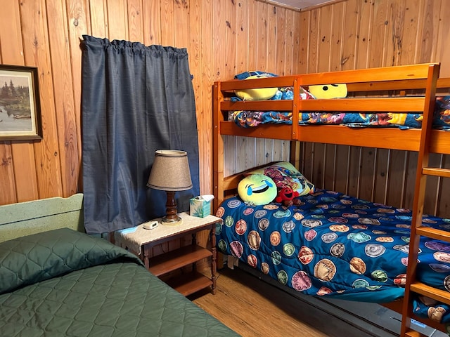 bedroom featuring hardwood / wood-style floors and wood walls