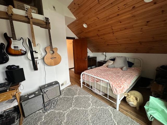 bedroom featuring dark hardwood / wood-style flooring, wooden ceiling, and lofted ceiling