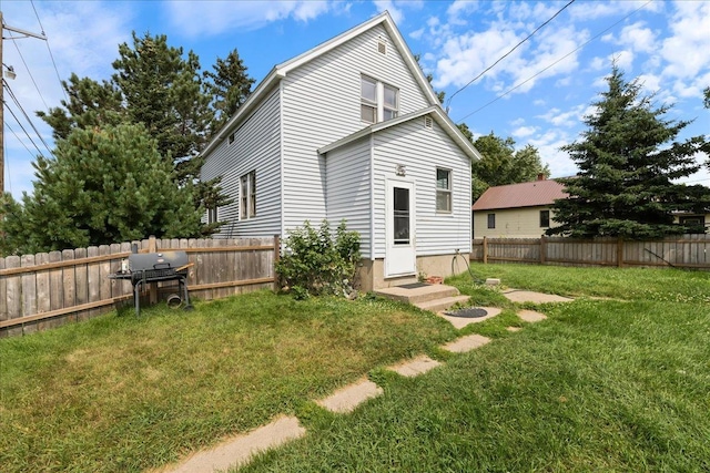 rear view of house featuring a yard