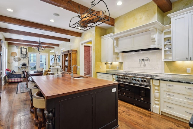 kitchen with double oven range, hardwood / wood-style flooring, sink, and tasteful backsplash