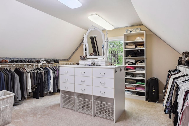 spacious closet with vaulted ceiling and light colored carpet