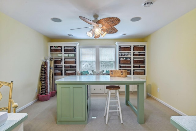 unfurnished office featuring ceiling fan and light carpet