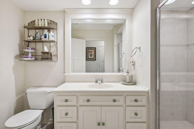 bathroom featuring a shower with door, toilet, and vanity