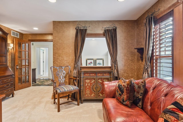 sitting room featuring light colored carpet and french doors