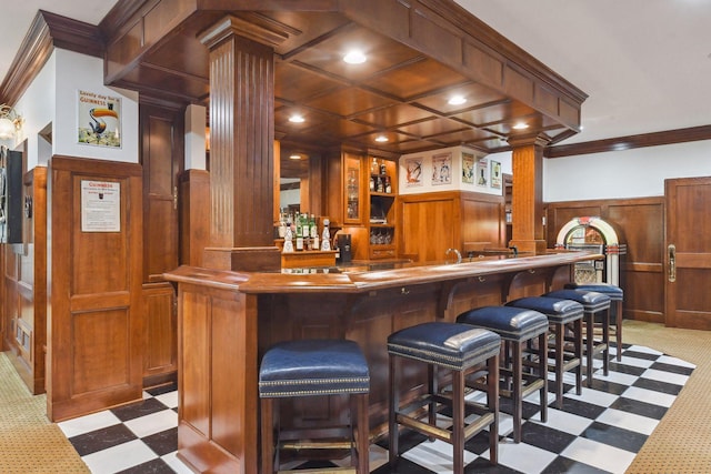 bar with crown molding, decorative columns, light carpet, and coffered ceiling