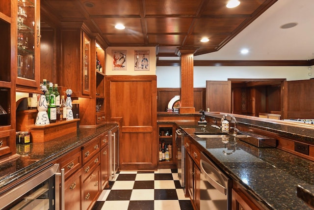 kitchen with beverage cooler, decorative columns, dishwasher, sink, and dark stone countertops