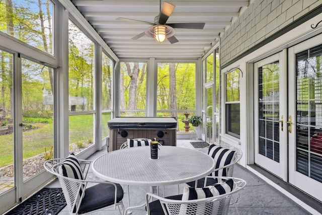 sunroom / solarium featuring beam ceiling, ceiling fan, and a healthy amount of sunlight