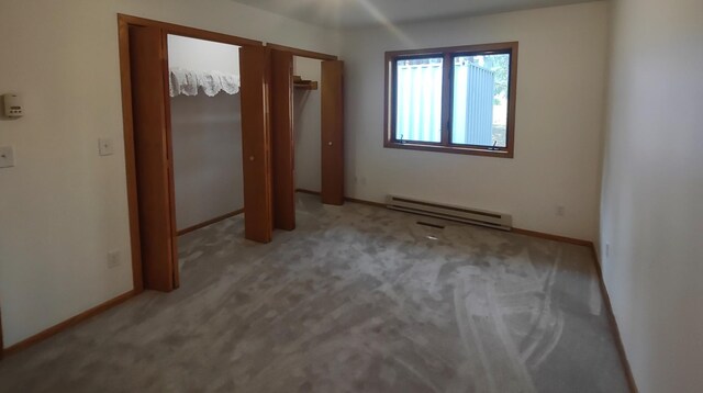 unfurnished bedroom featuring a baseboard radiator and light colored carpet