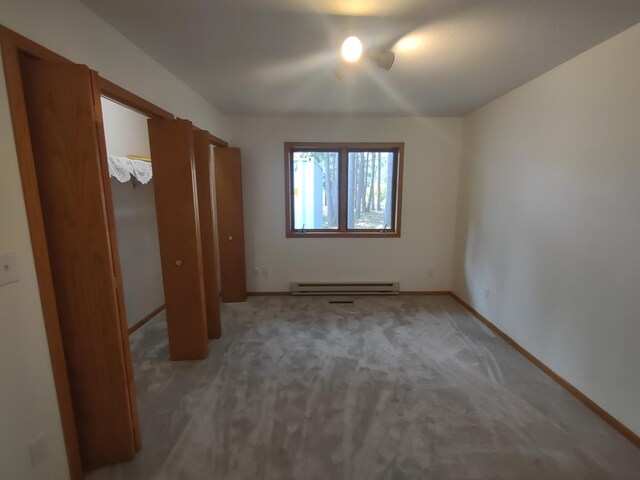 unfurnished bedroom with carpet flooring and baseboard heating