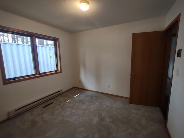 unfurnished room with a baseboard heating unit, a textured ceiling, and dark colored carpet