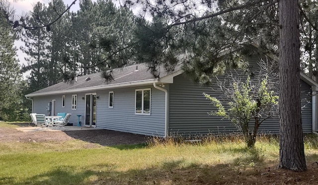 rear view of house with a patio area and a lawn