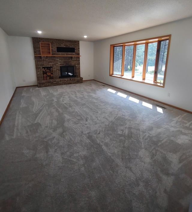 unfurnished living room with carpet flooring, a textured ceiling, and a fireplace