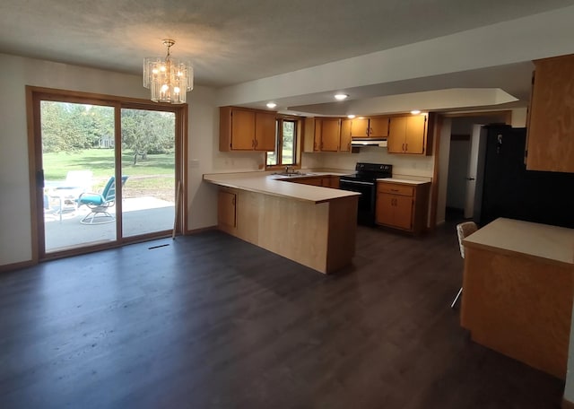 kitchen featuring black appliances, kitchen peninsula, decorative light fixtures, dark wood-type flooring, and a chandelier