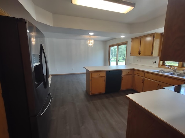 kitchen with black appliances, sink, kitchen peninsula, and dark hardwood / wood-style floors