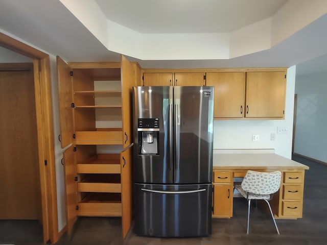 kitchen with stainless steel refrigerator with ice dispenser, built in desk, and light brown cabinetry