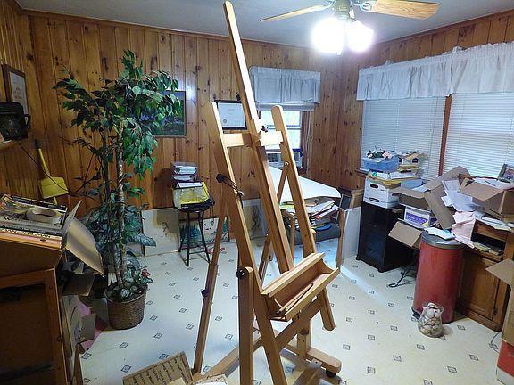 miscellaneous room with tile patterned flooring, wooden walls, and ceiling fan